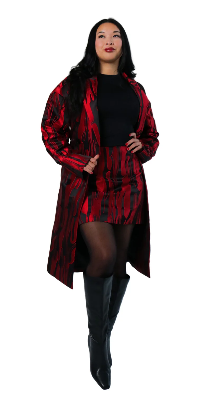 Woman wearing a red and black patterned coat on a white background