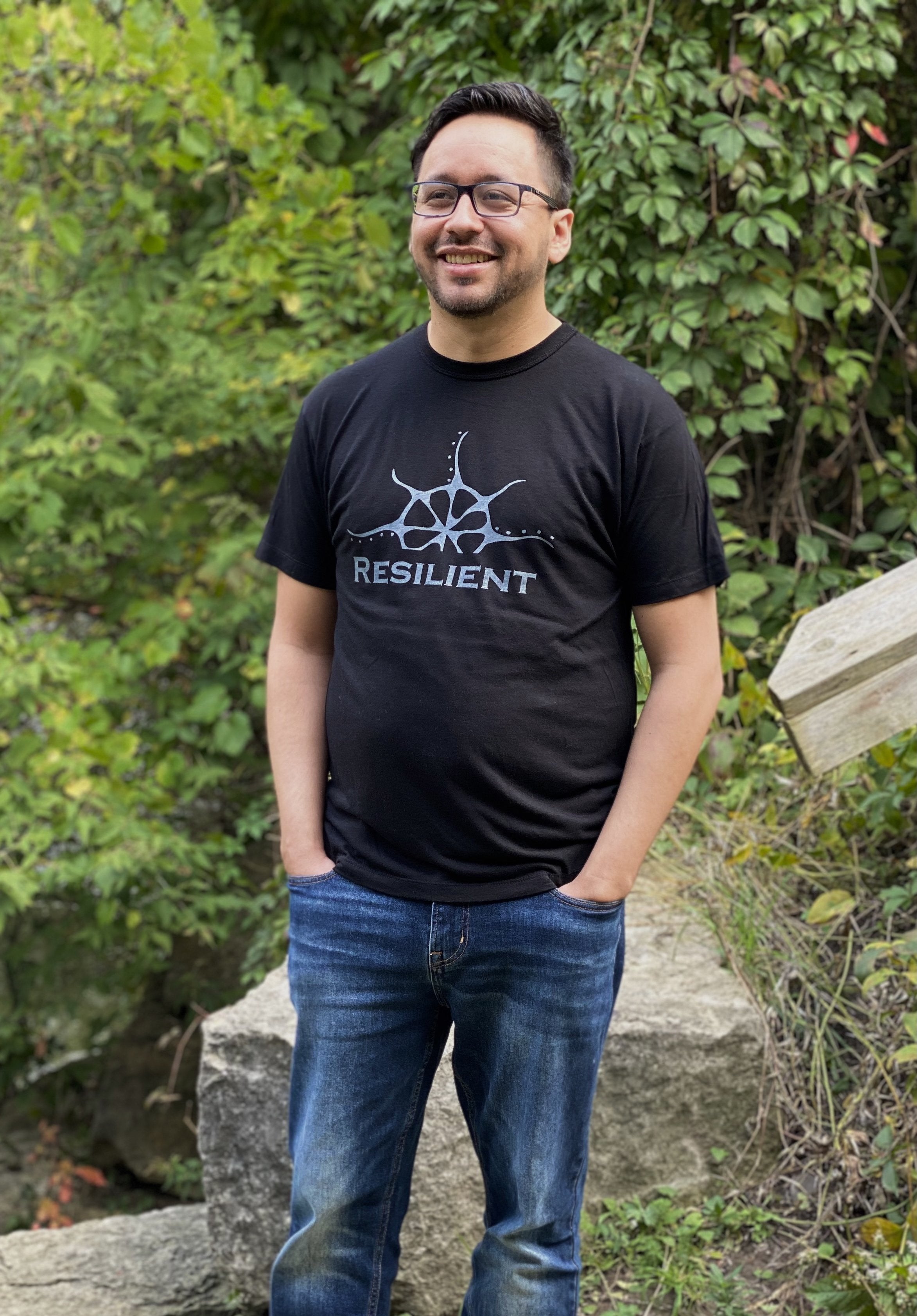Black bamboo unisex t-shirt on a man with a stylized rising sun graphic above the word &quot;Reslilient&quot;