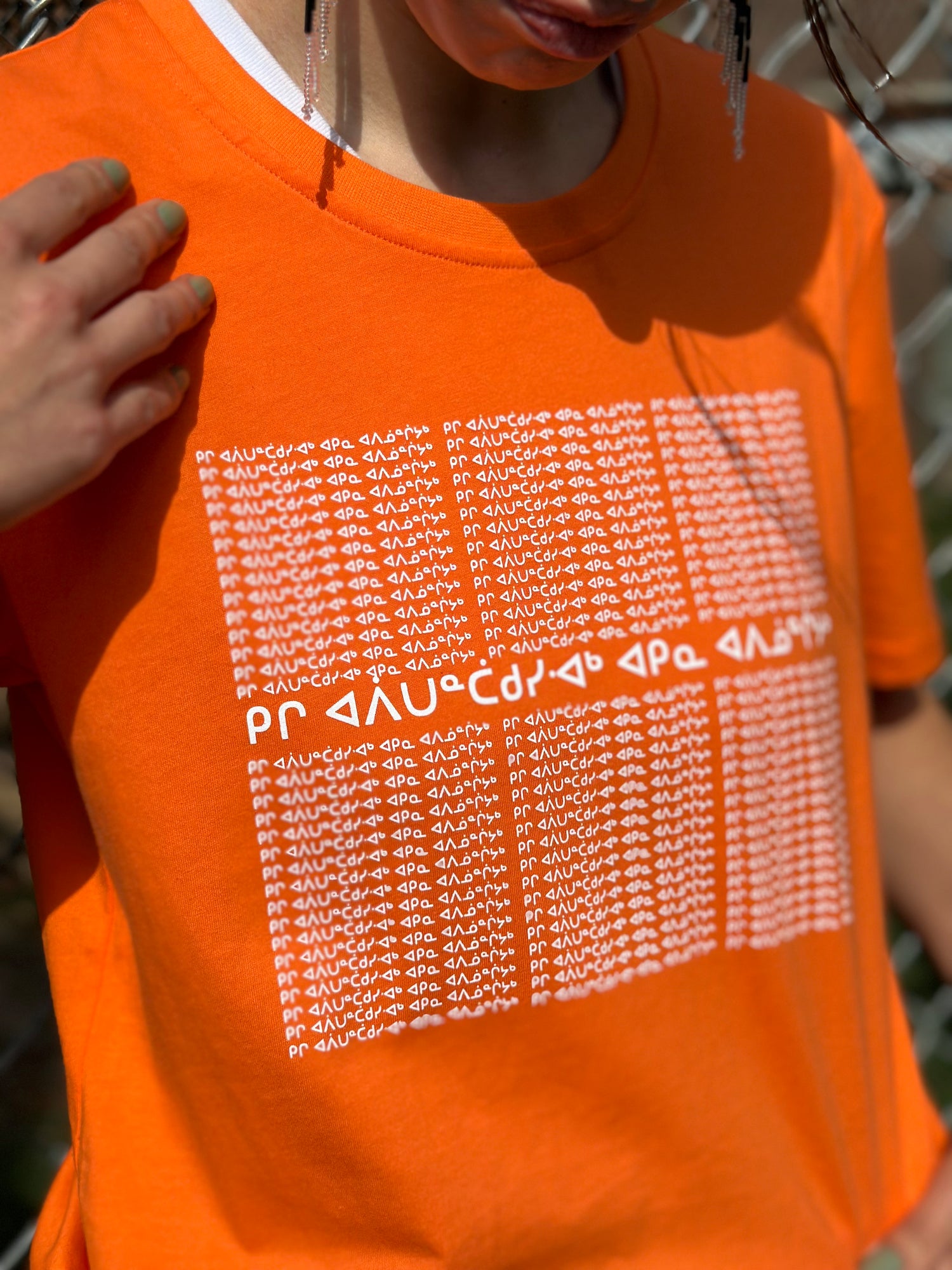 Anna, starting the conversation with aaniin by wearing an orange t-shirt with the 94 calls to action written in Anishinaabemowin syllabics honouring the Orange Shirt Society&