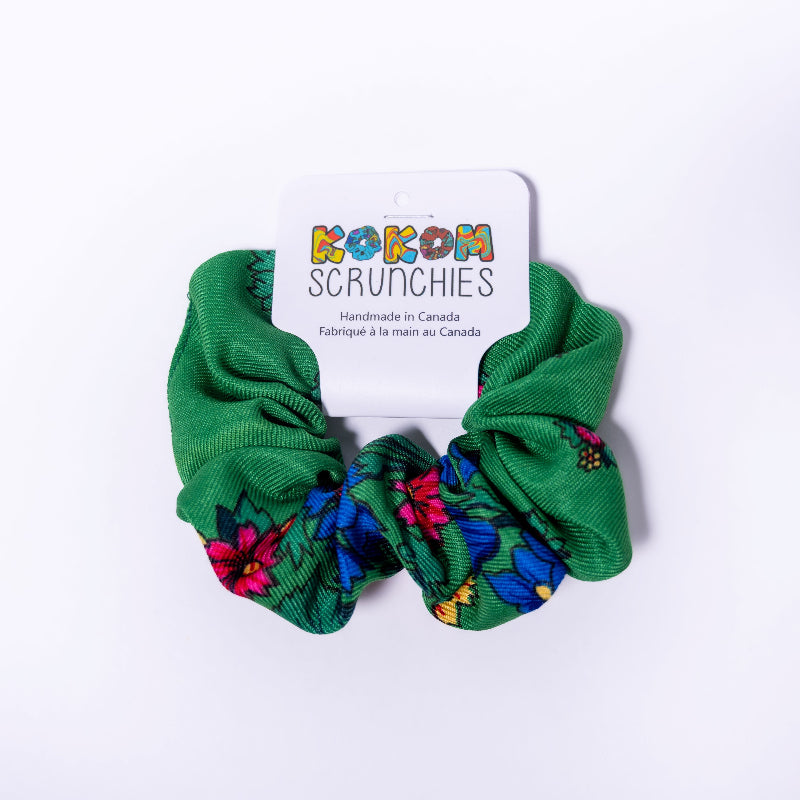 Green scrunchies with floral patterns on a white background, featuring a &