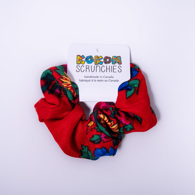 Red scrunchies with colorful patterns on a white background, featuring a &