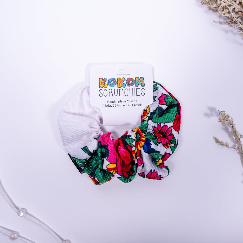 Colorful scrunchie with floral pattern on a white background, featuring &