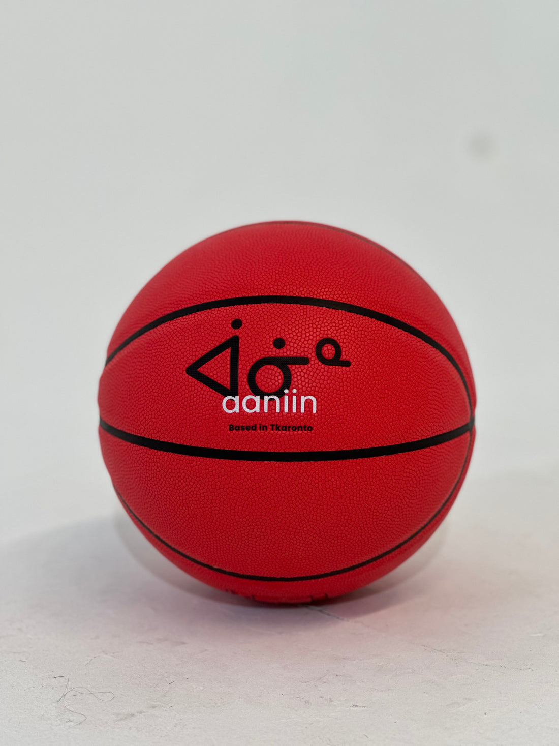 A red compost leather basketball with the brand name &