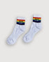 aaniin white ankle socks with our branding in black and white against the LGBTQIA flag rainbow colors.