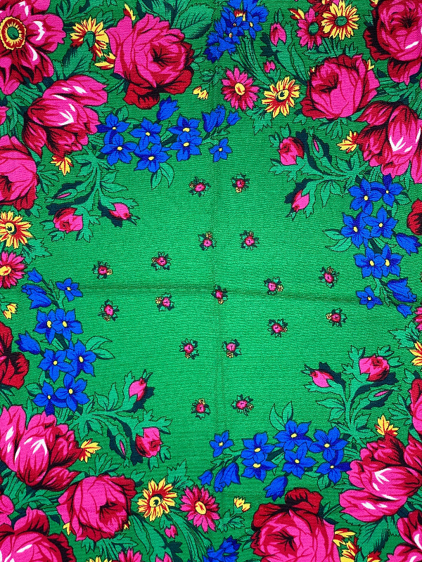 Floral patterned fabric with pink and blue flowers on a green background
