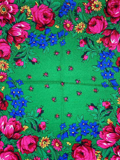 Floral patterned fabric with pink and blue flowers on a green background