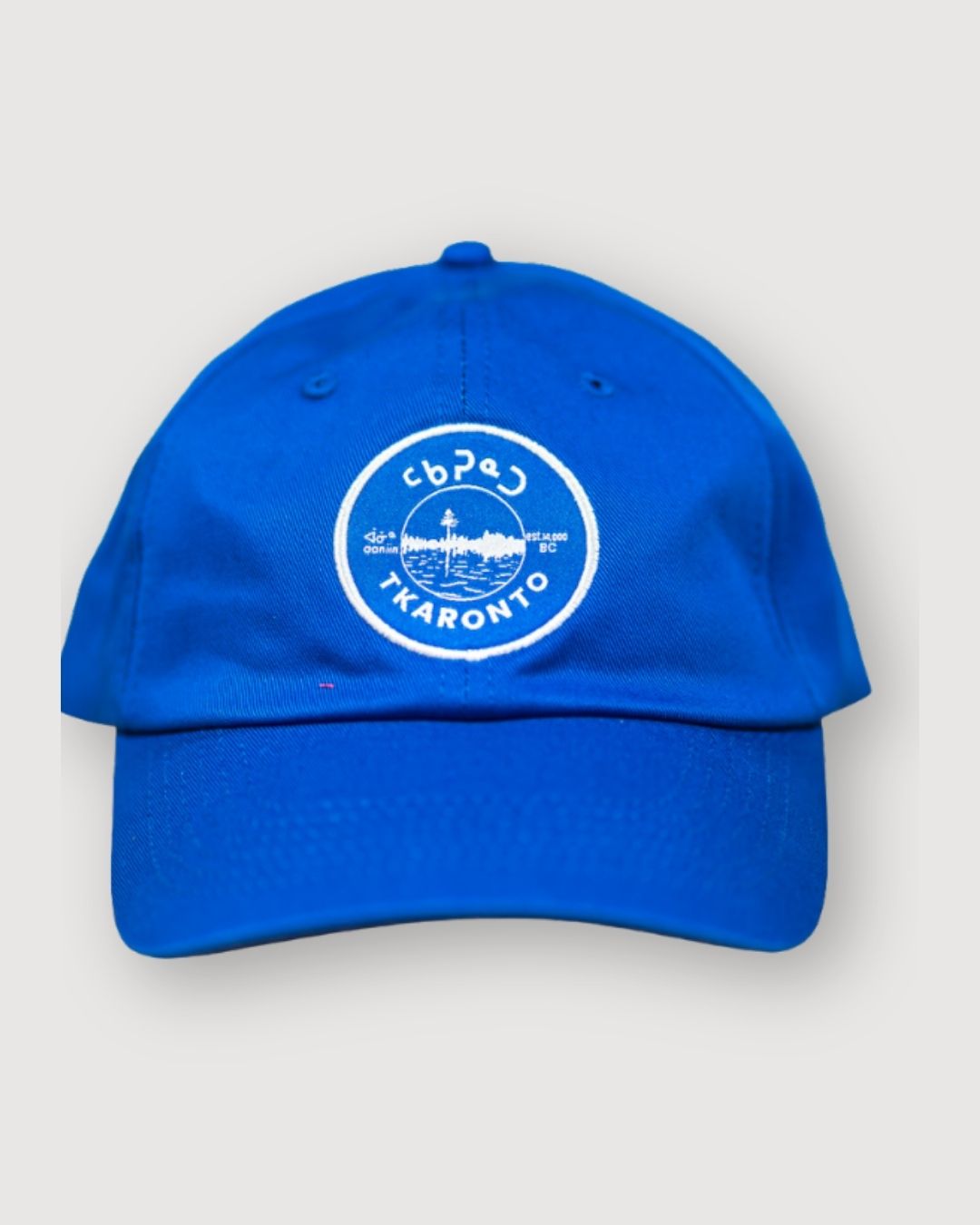 Blue aaniin dad cap with the tkaronto crest on it in white to resemble the Toronto sports teams that use white and blue